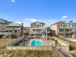 a home with a swimming pool and a house at Atlantic Watch in Kill Devil Hills