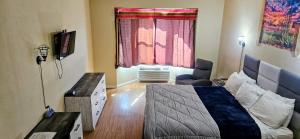 a bedroom with a bed and a desk and a window at Rodeway Inn Roswell in Roswell