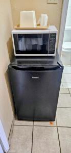 a microwave sitting on top of a refrigerator at Rodeway Inn Roswell in Roswell