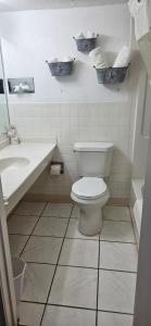 a white bathroom with a toilet and a sink at Rodeway Inn Roswell in Roswell +14 photos