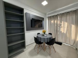 a dining room with a table and black shelves at Condomínio Aparte Hotel Laguna in Arraial do Cabo