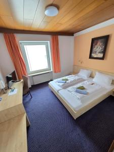 a hotel room with two beds and a window at Hotel BURGWALD in Passau
