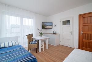 a bedroom with a bed and a table and a desk at Willa Di Mare in Karwia