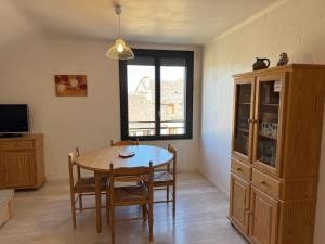 a dining room with a table and chairs and a window at La Fage in Nasbinals