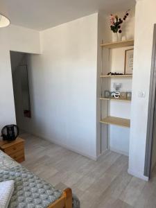 a room with a bed and a shelf with flowers at La Fage in Nasbinals +4 photos