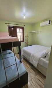 a bedroom with two bunk beds and a window at Cabana da lagoa in Osório