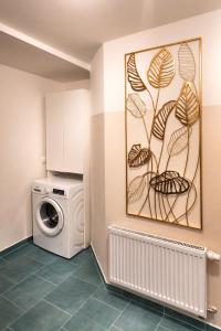 a laundry room with a washing machine and a painting at Ferienwohnung Saupe in Königshain
