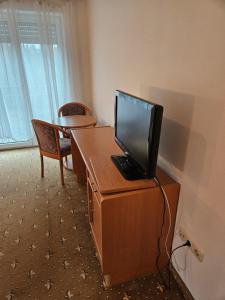 a television sitting on top of a wooden desk at Hotel BURGWALD in Passau