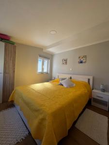 a bedroom with a large yellow bed with a window at Happy Home LP in Gruda