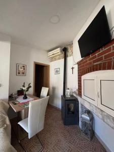 a living room with a table and a brick fireplace at Happy Home LP in Gruda