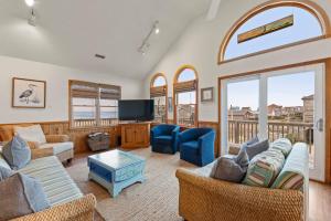 a living room with a couch and a tv at The Pickled Mermaid in Rodanthe