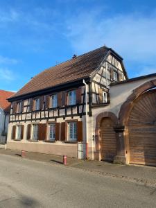 ein altes Gebäude mit einer großen Garage davor in der Unterkunft Le 128, duplex alsacien 10 personnes, piscine in Horbourg