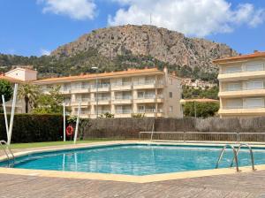 ein Hotel mit Swimmingpool vor einem Berg in der Unterkunft El Foraió in L'Estartit