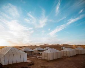 a group of white tents in the desert at Luxury Desert Central Camp in Merzouga