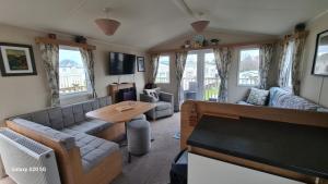 a living room with a couch and a table at Newydd nook in Anglesey