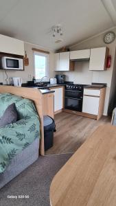 a kitchen with a couch and a table in a room at Newydd nook in Anglesey