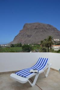un sillón azul y blanco con una montaña en el fondo en Casa Antonio, en Valle Gran Rey