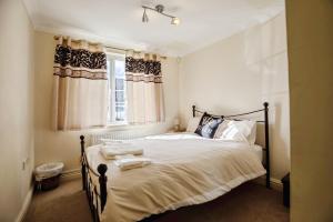 a bedroom with a large bed with a window at Spacious 2-Bed Family Flat in Wimbledon Near Tube in London