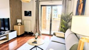 a living room with a couch and a tv at Parenthèse lumineuse près de Disney, Parking privé in Montévrain