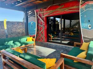 a living room with green couches and a stone wall at ChangoMango in La Ventana