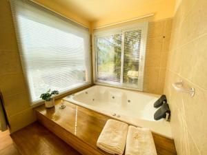 a bathroom with a bath tub and a window at Balcones de La Cumbrecita in La Cumbrecita +29 photos