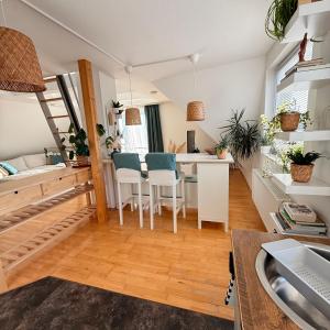 a kitchen and living room with a dining table and chairs at Gemütliche Galeriewohnung im Grünen in Trappenkamp