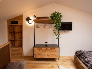 a bedroom with a dresser with a plant on the wall at SKY LOVE Luxury Chalet in Andalo