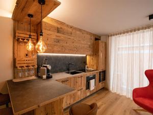 a kitchen with wooden walls and a counter with a sink at SKY LOVE Luxury Chalet in Andalo