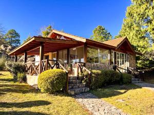 a small house with a wooden roof at Balcones de La Cumbrecita in La Cumbrecita