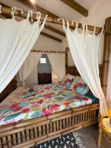 a bedroom with a bed with a canopy at Le Chalet des Rêves Ensoleillés in Saint-François