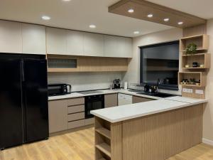 a kitchen with a black refrigerator and white cabinets at Резиденция БАЛМОРА in Kalofer