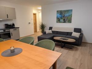 a living room with a couch and a table at Apartment Auszeit am See in Uttendorf