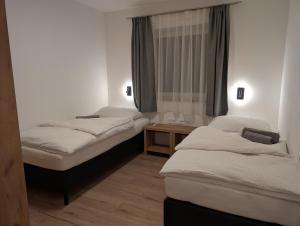 a room with two beds and a table at Apartment Auszeit am See in Uttendorf