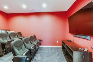 a red room with chairs and a flat screen tv at Pier View Oasis - Nags Head MP 16, Oceanfront, Elevator, Theater, Pool, Hot Tub, Pets OK in Nags Head