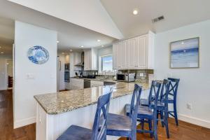 a kitchen with blue chairs at a counter at Pier View Oasis - Nags Head MP 16, Oceanfront, Elevator, Theater, Pool, Hot Tub, Pets OK in Nags Head