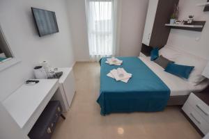a small bedroom with a bed with a blue blanket at Pool Apartments & Rooms Mare in Novalja