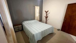 a small room with a bed with a striped blanket at Blend- Casa descanso Cafayate in Cafayate