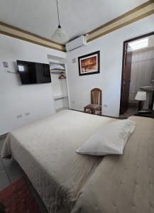 a bedroom with a large white bed with a pillow at Espacio Verde in Salta