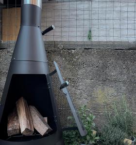 a grill with a knife and some wood in it at Il cuore della Valtellina - giardino privato in Caiolo +21 photos