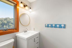 a white bathroom with a sink and a mirror at The Sand Wedge in Kitty Hawk +35 photos