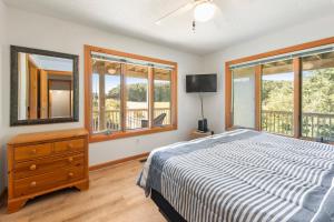 a bedroom with a bed and a dresser and windows at The Sand Wedge in Kitty Hawk