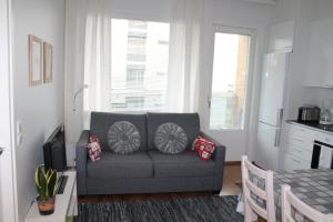 ein Wohnzimmer mit einem grauen Sofa und einem Tisch in der Unterkunft Apartment Nallisuites in Oulu