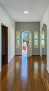an empty room with white walls and wooden floors at Studio para 7 pessoas com Ar Condicionado e 2 Garagem in Uberlândia