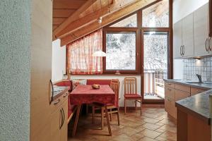 eine Küche mit einem Tisch mit einer roten Tischdecke in der Unterkunft Ferienwohnung Marienkäfer Rückzugsort inmitten der Natur mit Bergblick in Klobenstein
