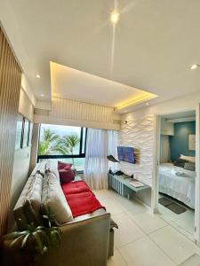 a bedroom with a bed and a large window at apart hotel 2 quartos frente mar in Salvador