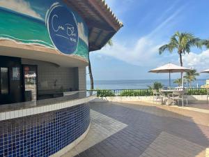 a restaurant on the beach with a table and an umbrella at apart hotel 2 quartos frente mar in Salvador