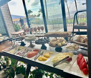 a buffet with many different types of food on a table at apart hotel 2 quartos frente mar in Salvador