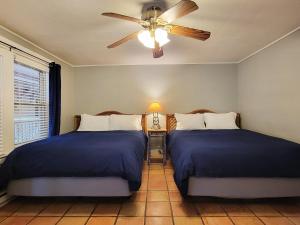 a bedroom with two beds and a ceiling fan at La Veta Inn in La Veta