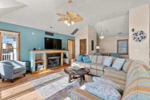 a living room with a couch and a tv at Anchors Away in Corolla