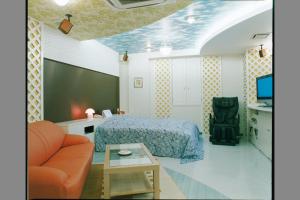 a bedroom with a bed and a tv and a couch at ホテルパークアベニュー in Nagoya +15 photos